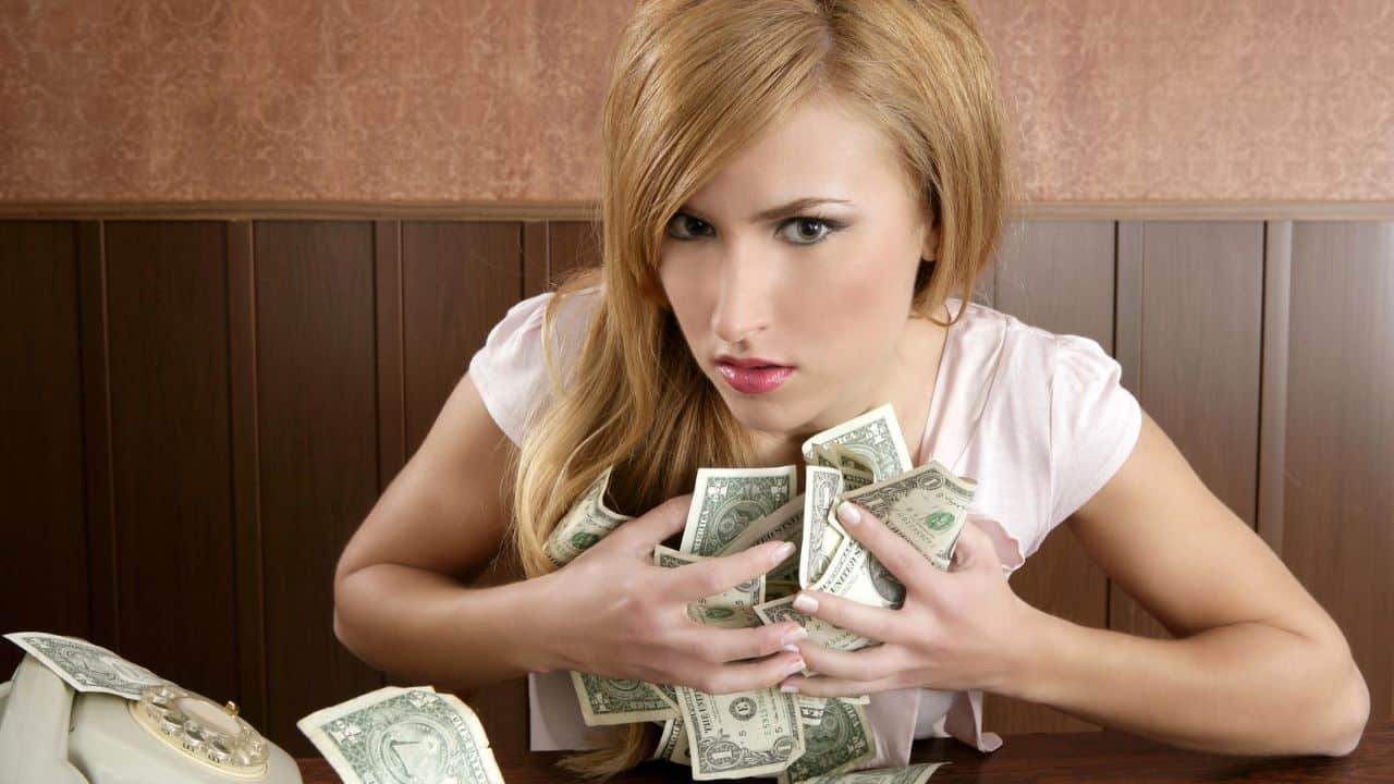 9 Investing Rules People Live By When Self-Managing Their Investments womnan holding a lot of money