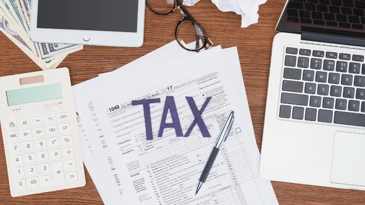 10 Expert Tips On How Students Can Pay Off Their Student Loans Quicker Top view of tax forms, digital devices and crumpled paper balls on desk