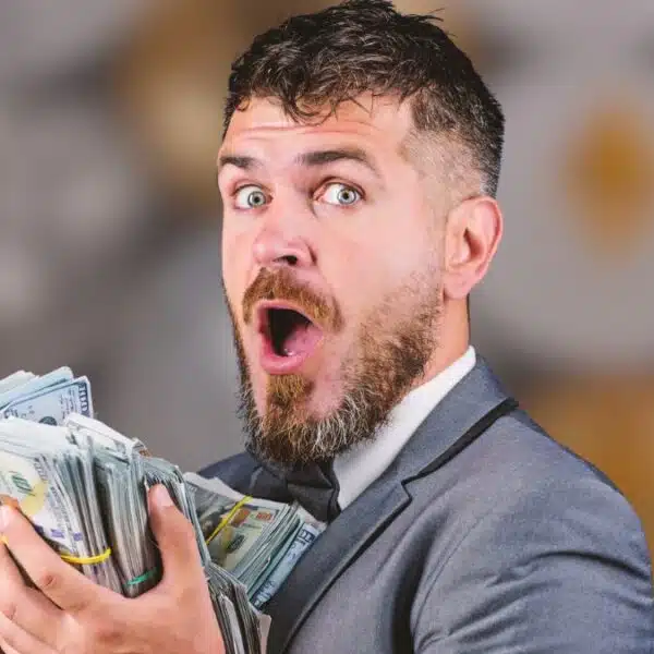 man holding cash in front of crypto