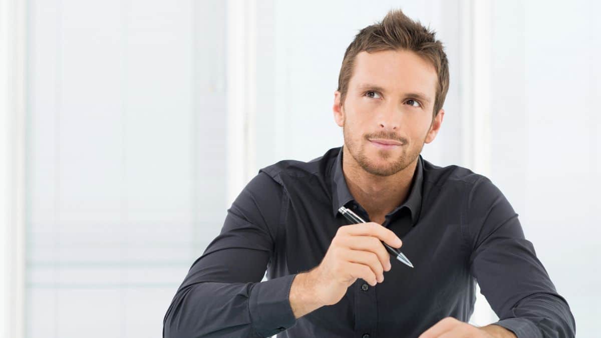 Signs That Can Predict Real Wealth man sitting at a desk thinking