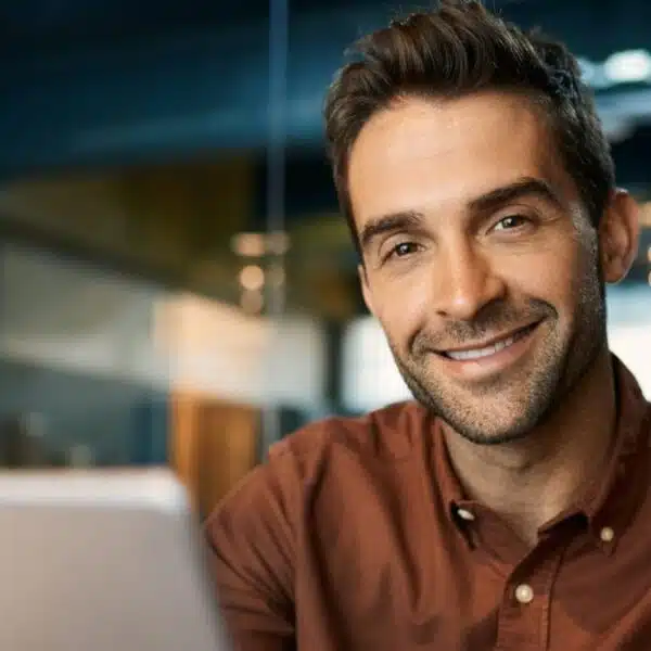 man with tablet in office smiling