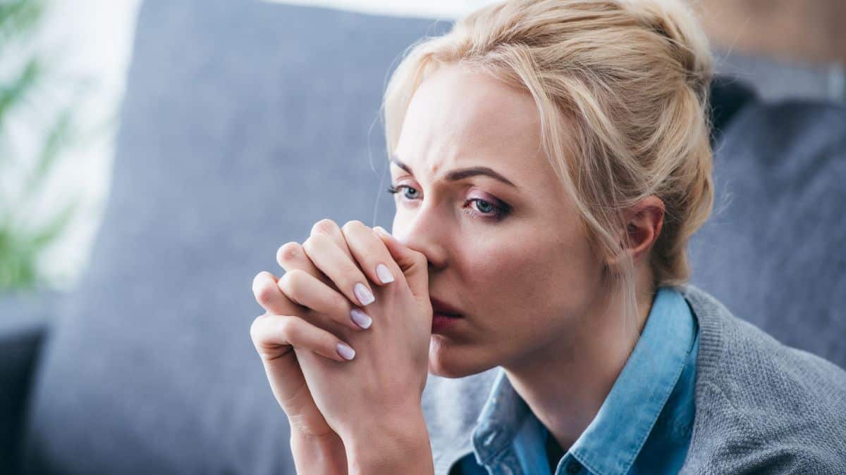 Oversights That Can Sink New Property Hosts woman concerned sitting on a couch