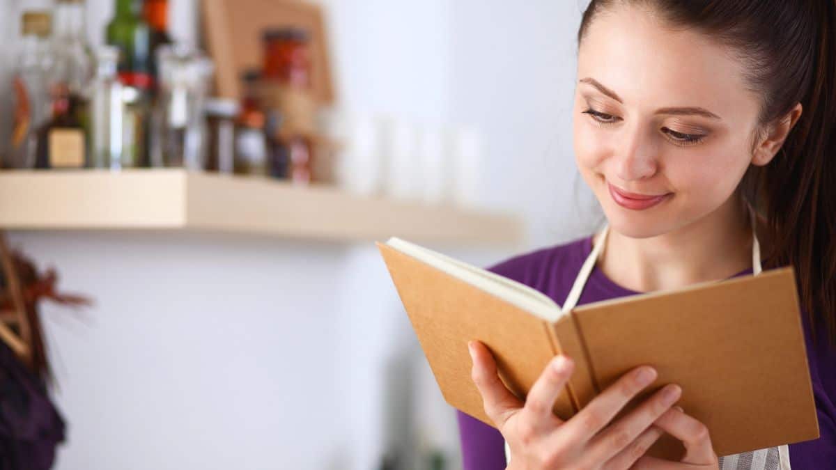 Kitchen Clutter Mistakes Costing You Money woman with a cookbook