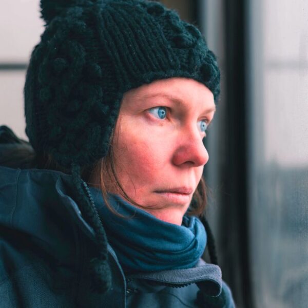 woman cold looking out the window sad