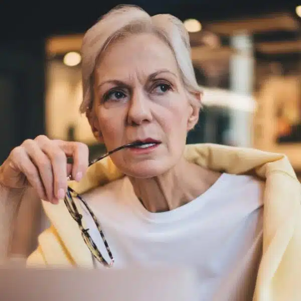 senior woman biting on her glasses