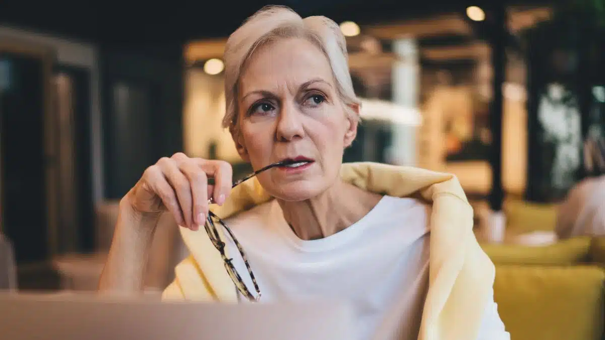senior woman biting on her glasses