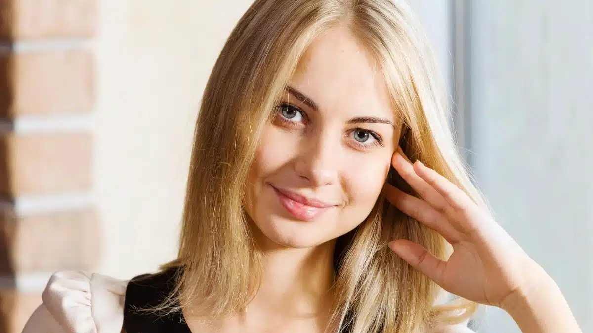 blonde woman smiling thinking in office