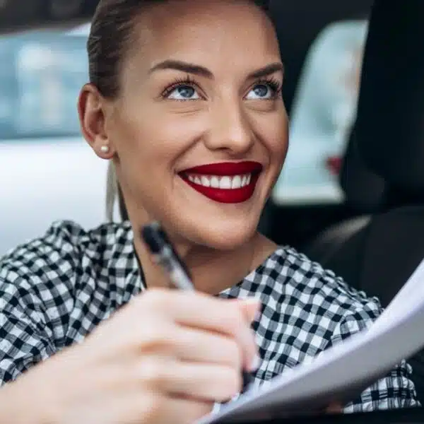 woman buying a car signing documents