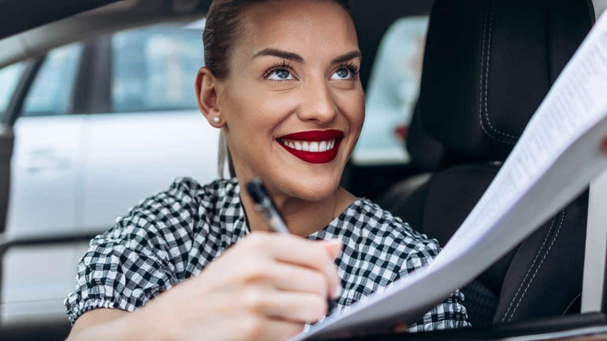 woman buying a car signing documents