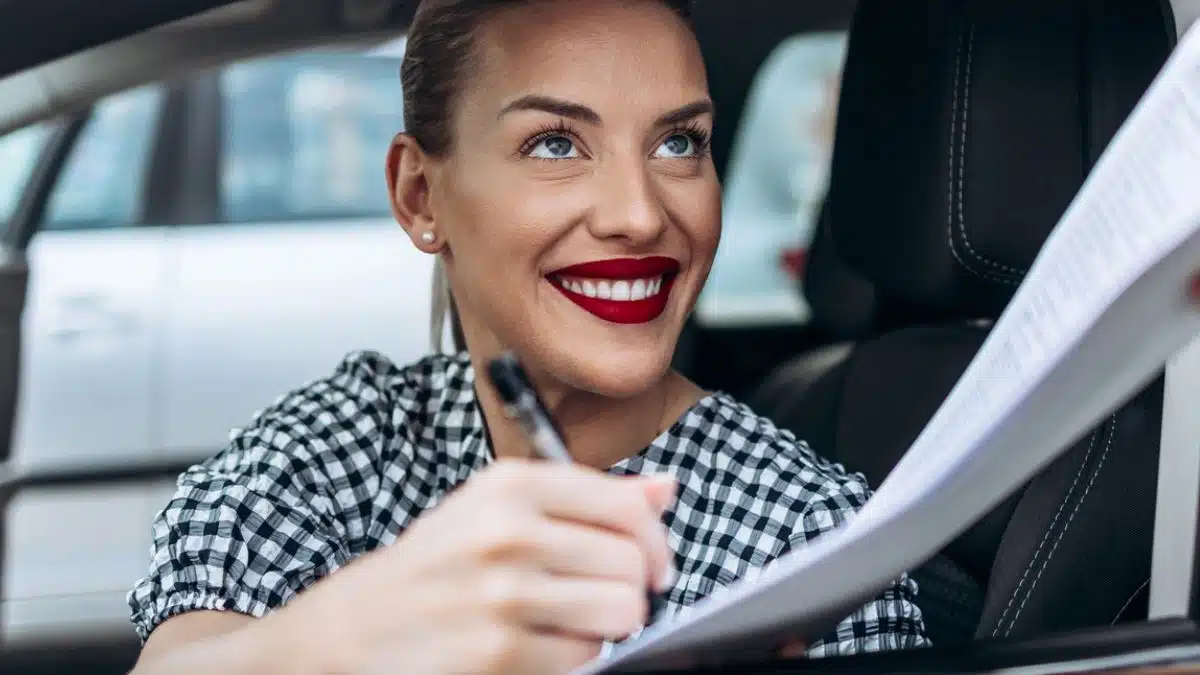 woman buying a car signing documents