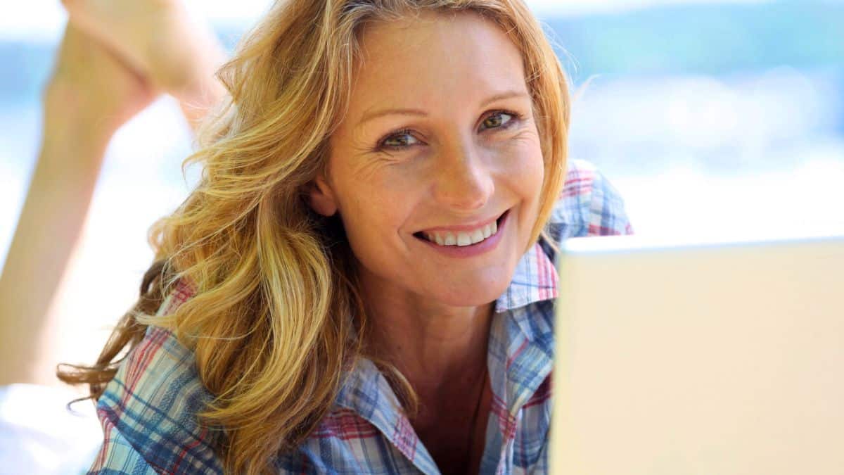 woman laptop on beach smile