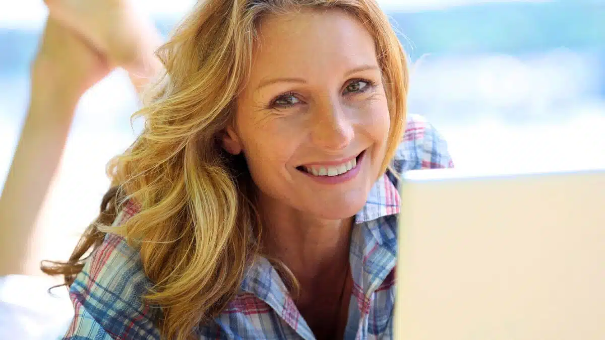 woman laptop on beach smile
