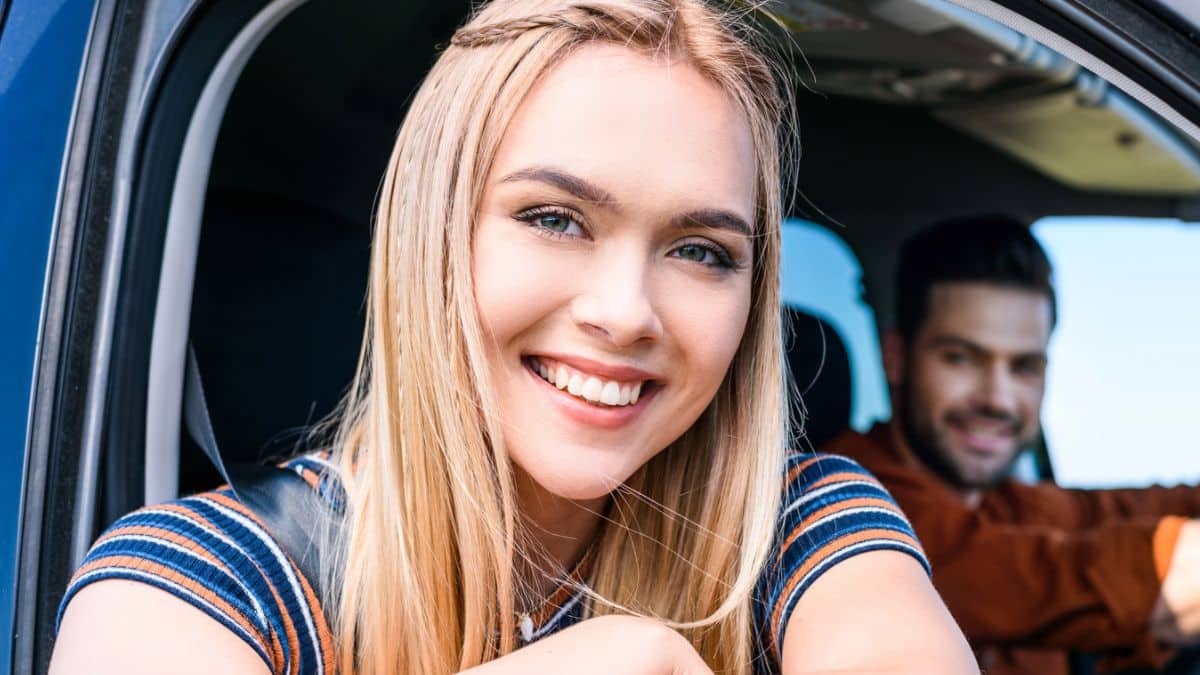 friends driving in a car smiling