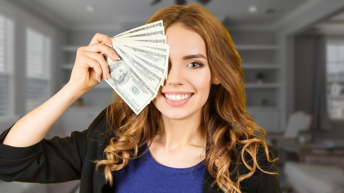 woman holding cash in coat suit