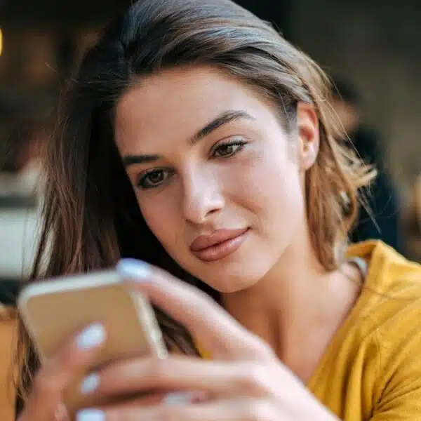 woman looking at her phone in a coffee shop