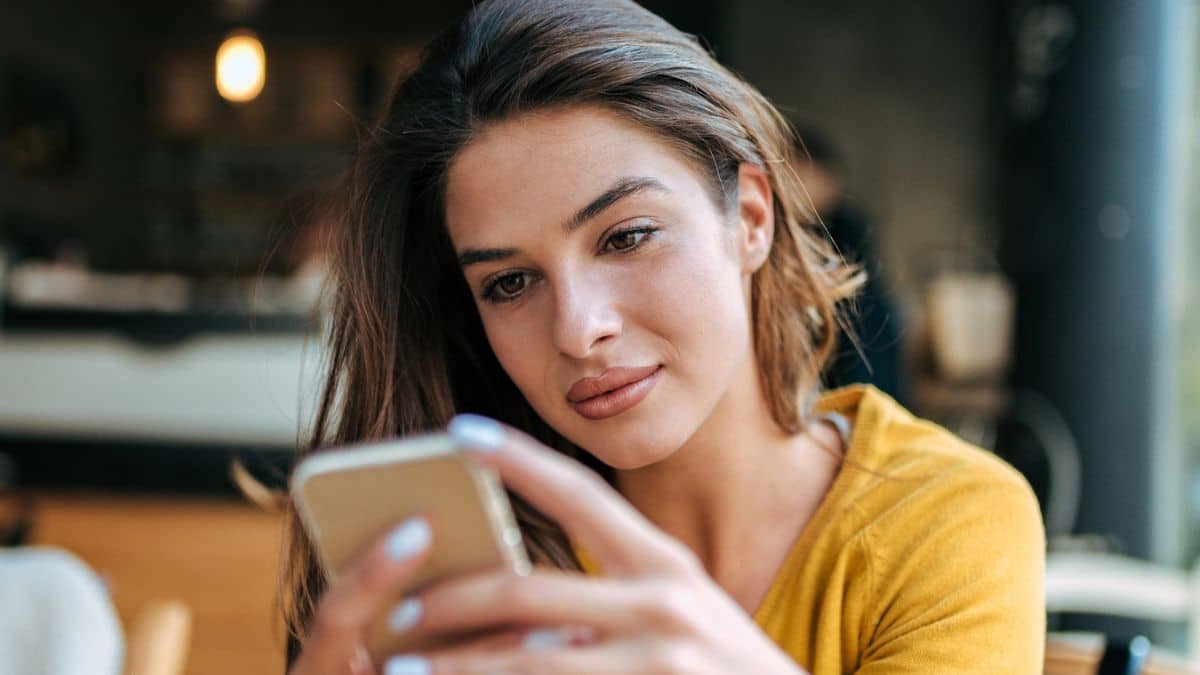 woman looking at her phone in a coffee shop