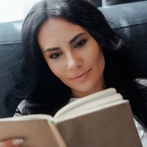 laying on a couch reading a book
