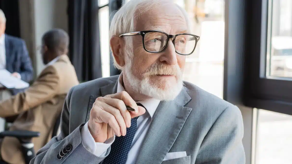 senior man glasses looking at the window suuit and tie