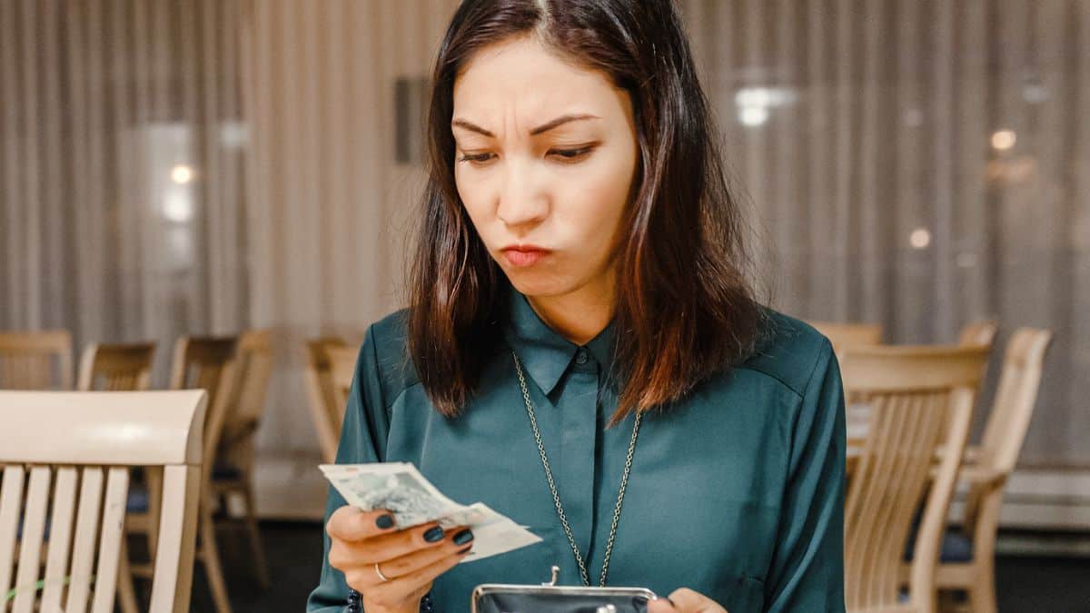 woman restaurant looking at bill money