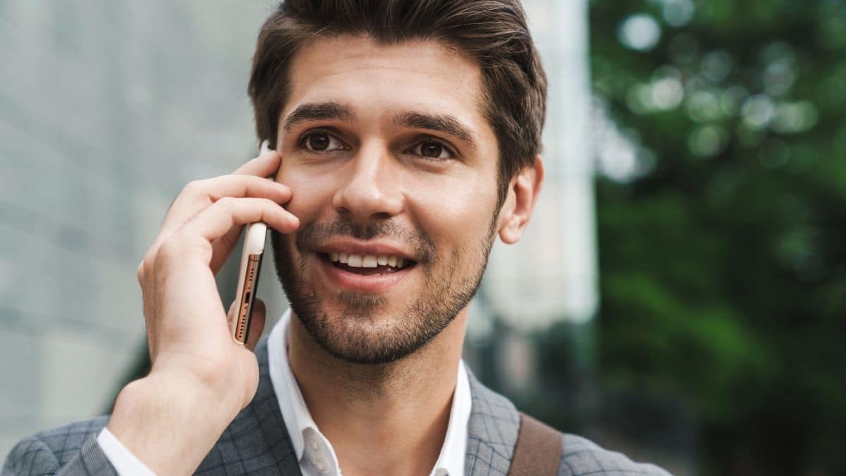 young man suit holding phone talking