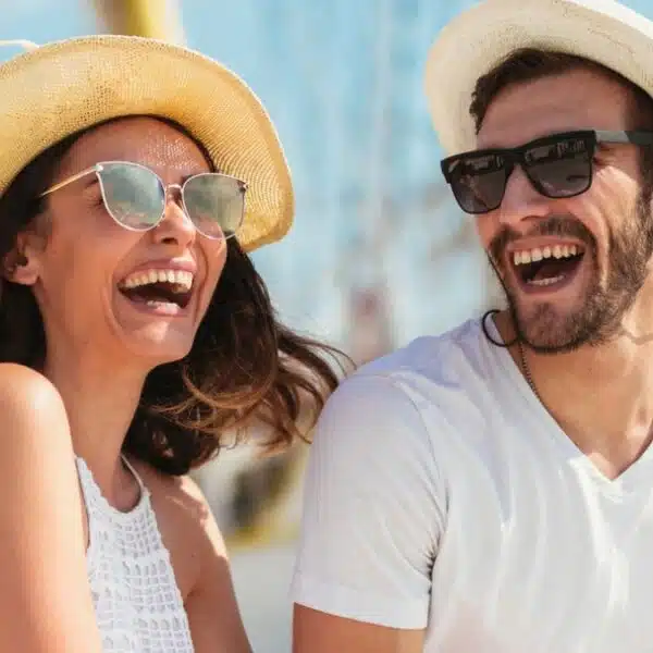 couple laughing with sunglasses hat boat