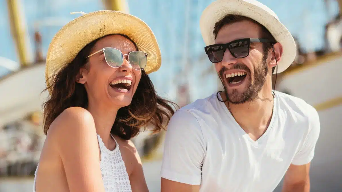 couple laughing with sunglasses hat boat