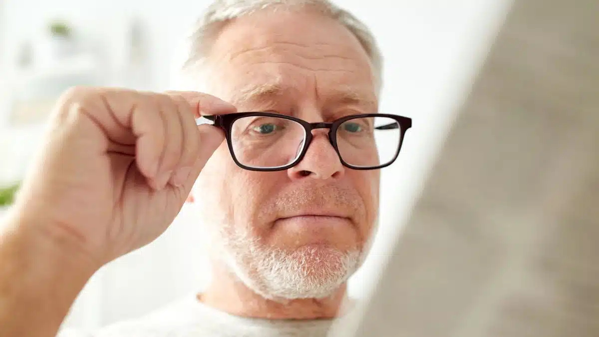 man senior glasses looking at news paper