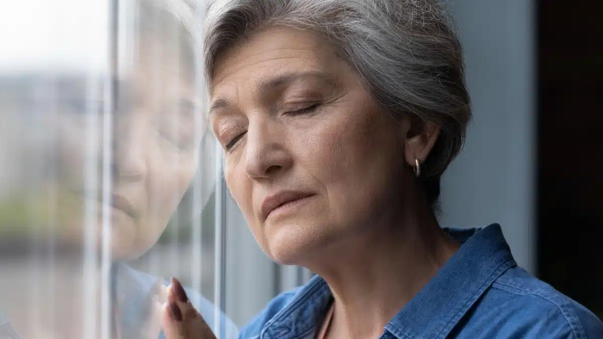 mature woman regret at a window