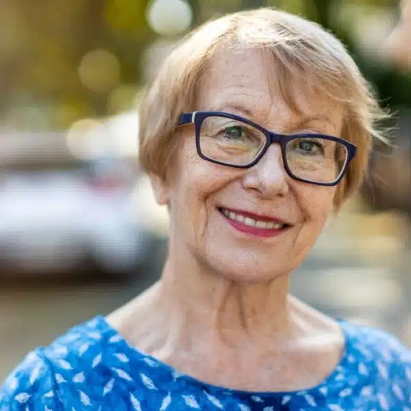 senior woman smiling outside of home