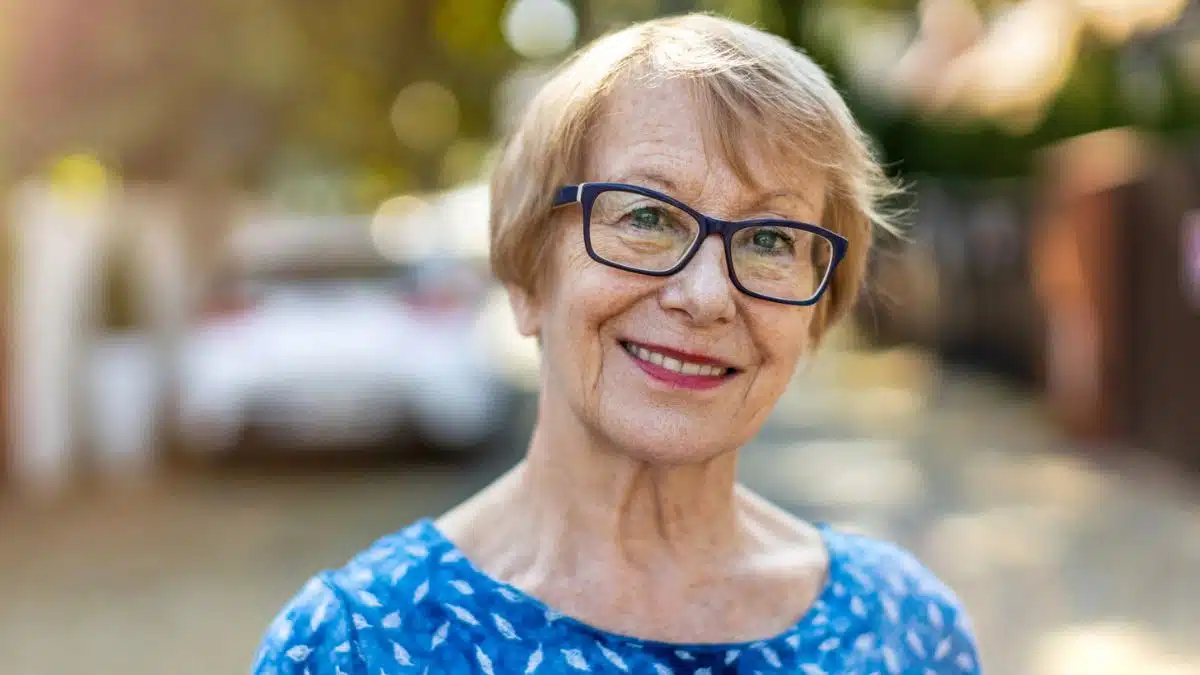 senior woman smiling outside of home