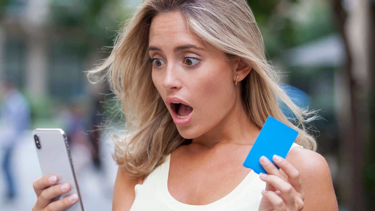 woman shocked holdling phone and credit card