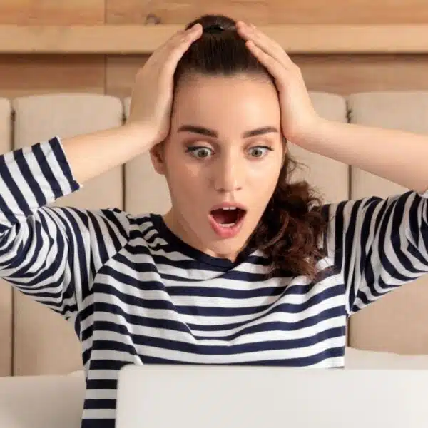 woman shocked in bed with laptop