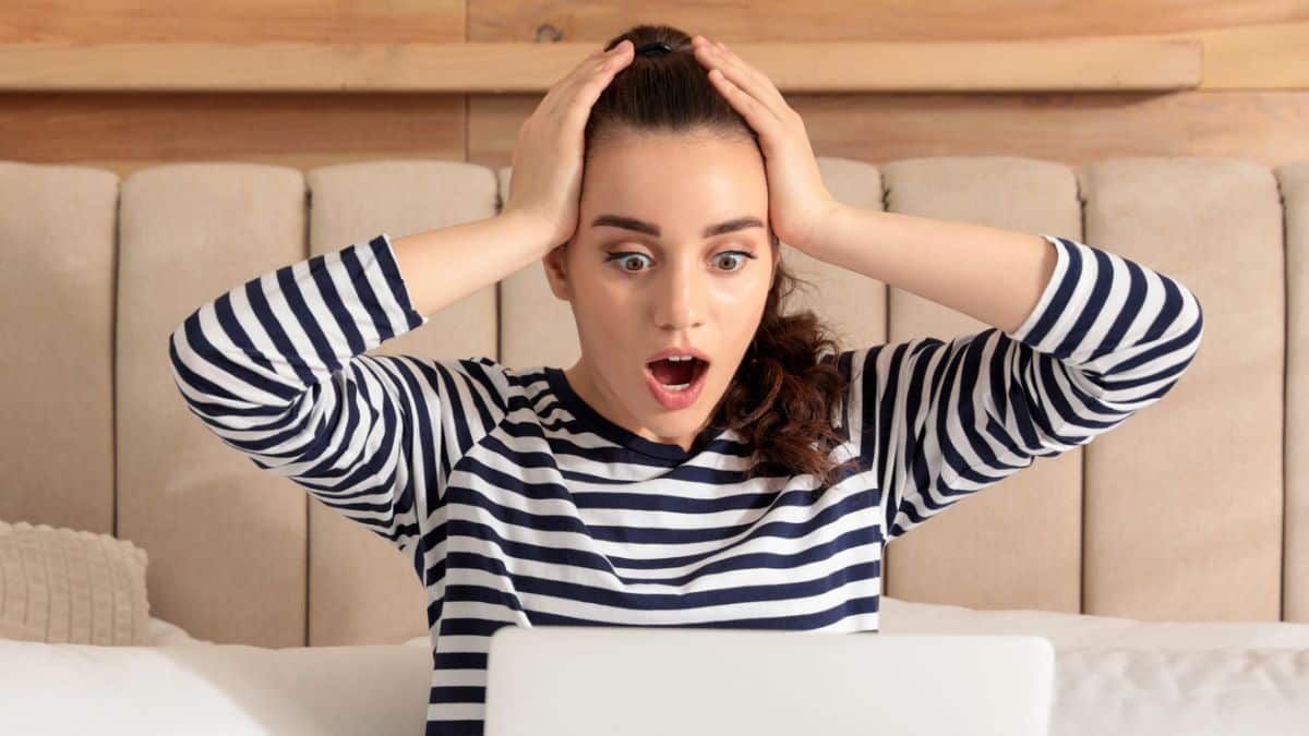 woman shocked in bed with laptop
