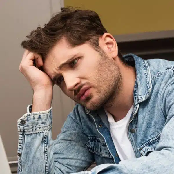 man jean jacket sad outside laptop
