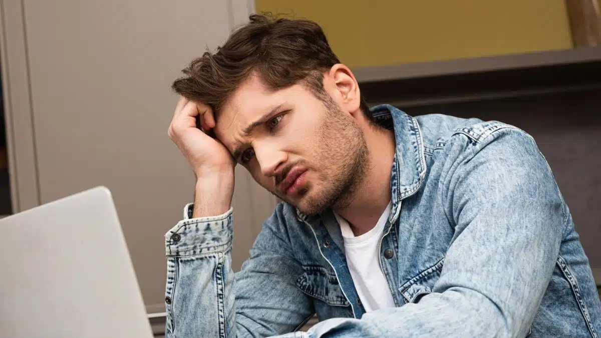 man jean jacket sad outside laptop