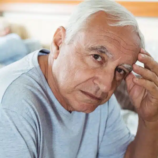 senior man sitting on his bed