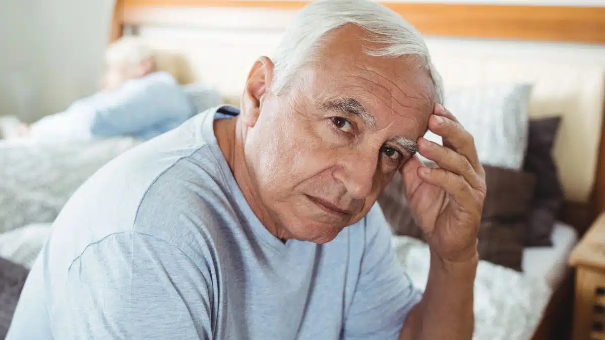 senior man sitting on his bed