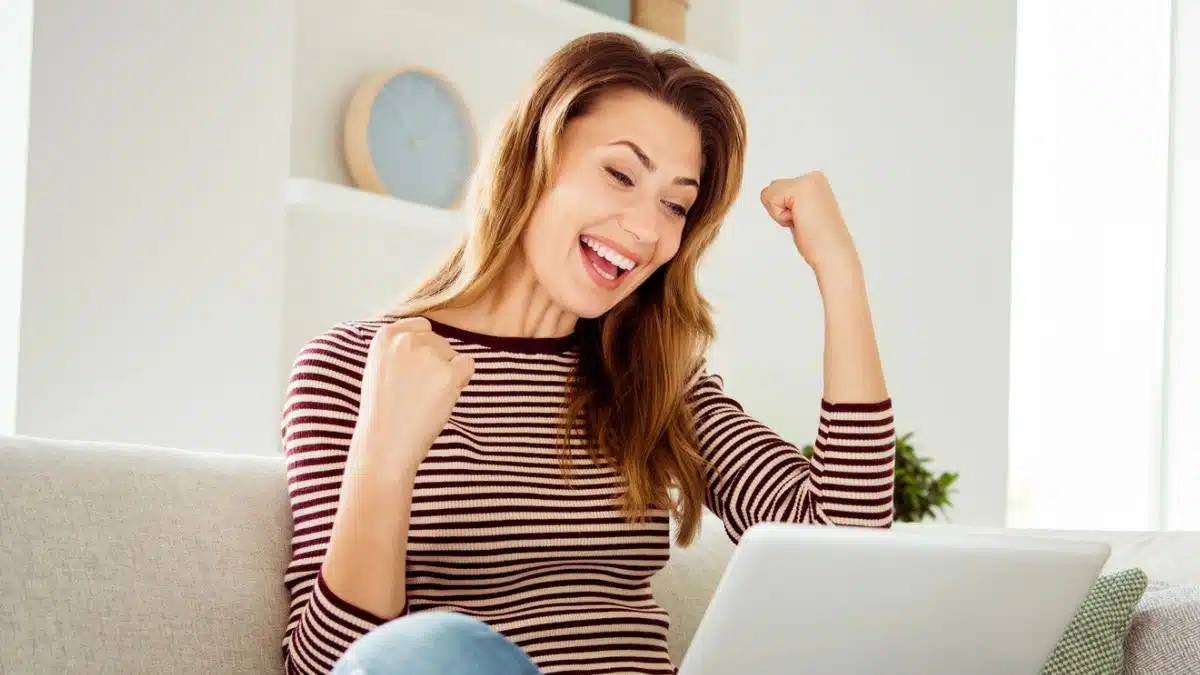woman excited looking at her laptop