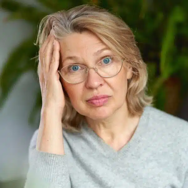 mature woman confused with glasses on couch