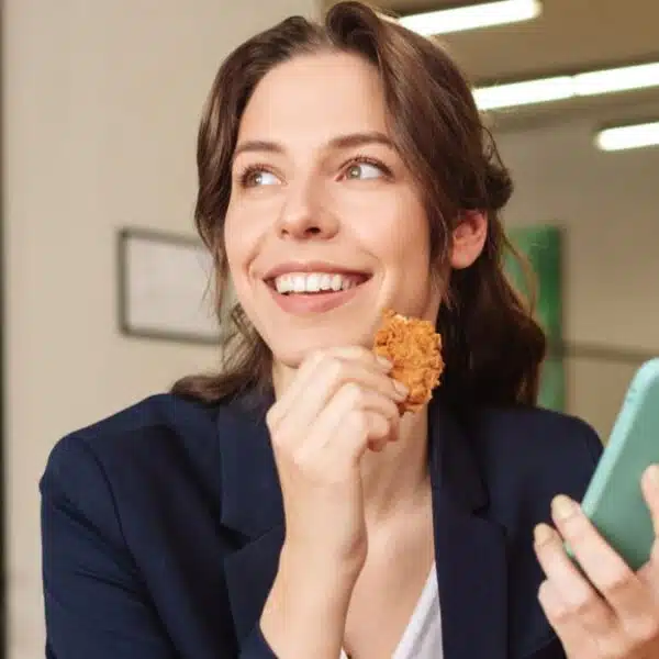 woman eating at her desk phone