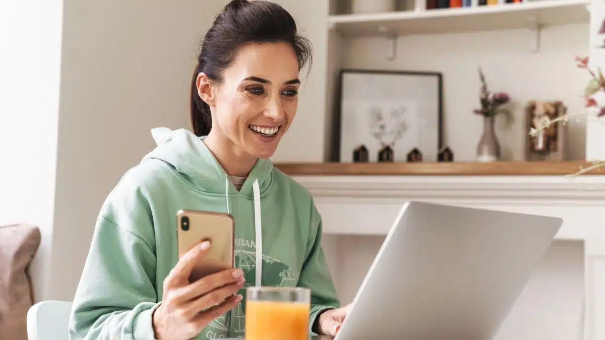 woman laptop kitchen orange juice