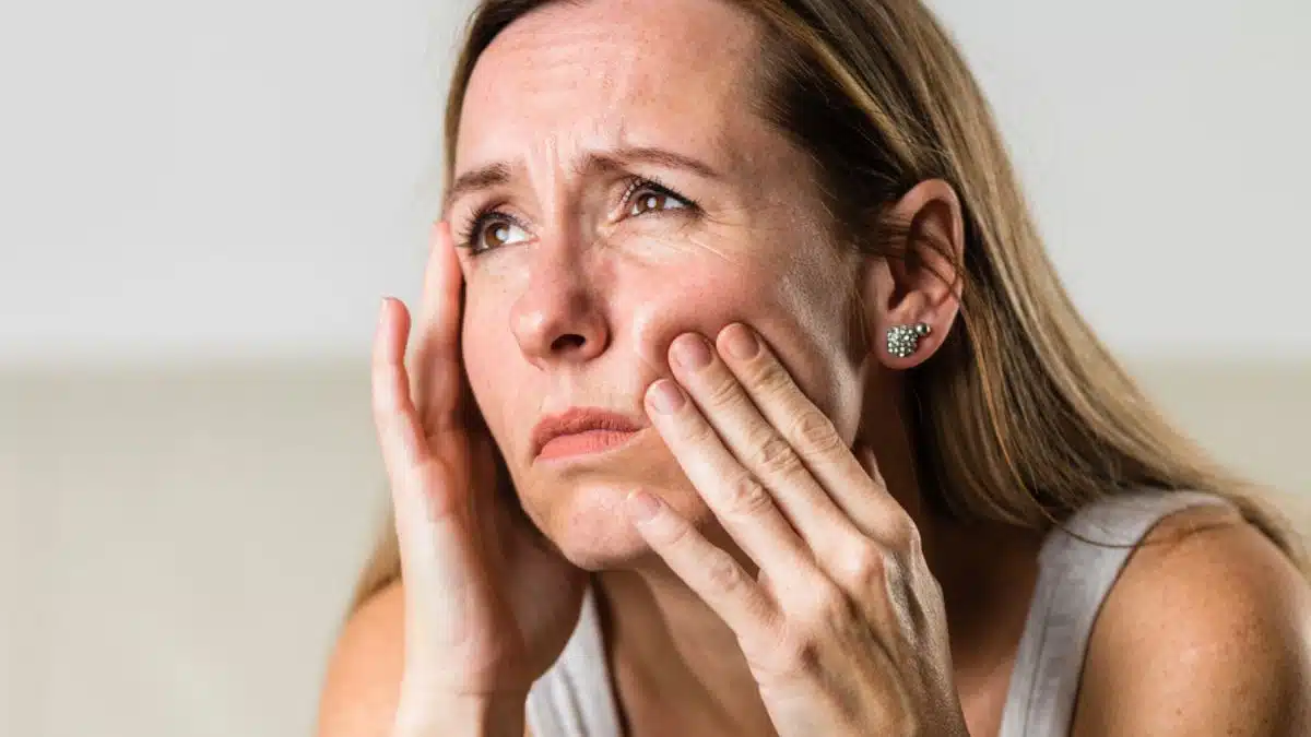 woman looking out her window sad