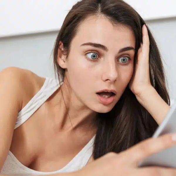 woman shocked reading the news on her phone