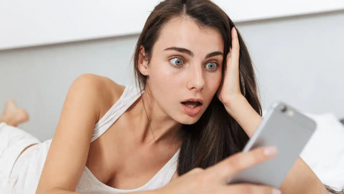 woman shocked reading the news on her phone