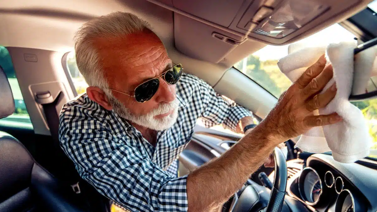 man with sunglasses cleaning his car