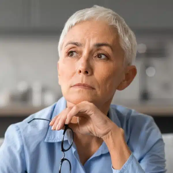 mature woman glasses thinking to herself