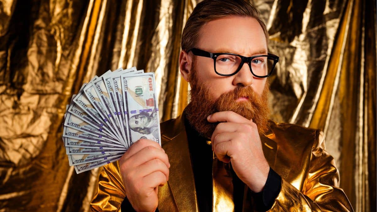 man glasses gold suit holding cash