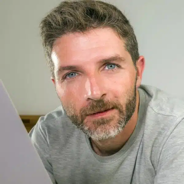 mature man reading a book in bed
