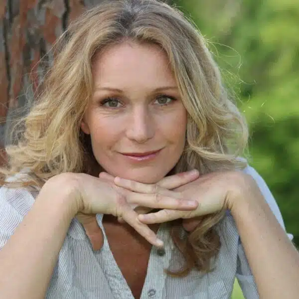 mature woman leaning on a tree