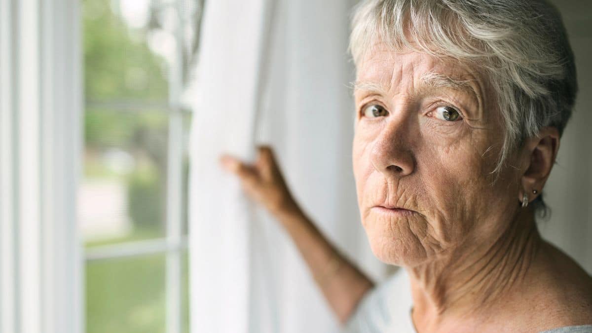 mature woman staring out the window